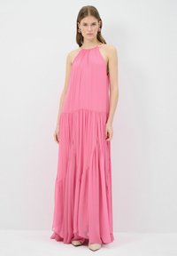 Vestido maxi fluido en un vibrante color rosa, hecho de una tela ligera. Diseño de cuello halter con un cuerpo fruncido y falda en capas. Simple y elegante.