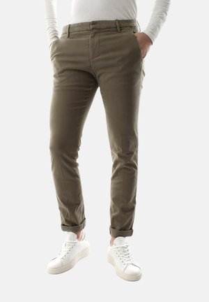Pantaloni chinos in verde oliva, realizzati in un tessuto morbido. Presentano una vestibilità affusolata, orlo risvolto e tasche laterali. Abbinati a sneakers bianche.