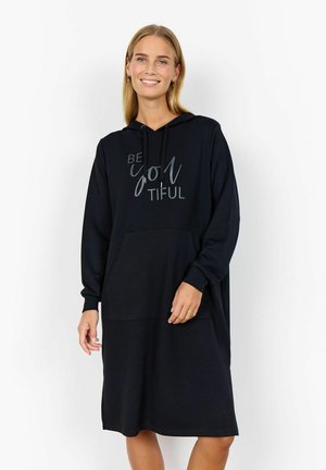 Svart hoodieklänning i mjukt material, har framsida ficka, långa ärmar och texten "BE you tiful" i silver. Normal passform.