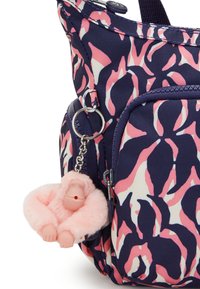 Navy and pink patterned tote bag with a soft pink monkey keychain attached. Features zippered pockets and fabric handles.