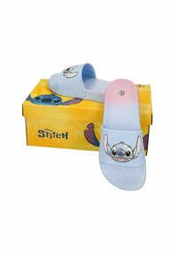 Sandales légères pour enfants en dégradé bleu clair et rose avec l'impression du visage du personnage Stitch, posées sur une boîte jaune estampillée Disney Stitch.