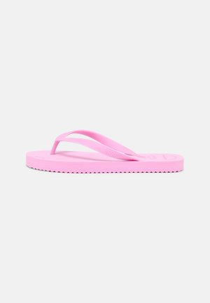 Enkelt pink gummiflip-flop med teksturerede stropper og rillede sål, vist fra siden på en ensfarvet lys baggrund.