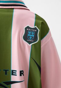 Short-sleeved shirt in green and pink satin fabric, featuring a black and blue embroidered shield logo with "BOTTER ANTWERP" text.