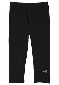 Czarne legginsy sportowe wykonane z elastycznego materiału, charakteryzujące się dopasowanym krojem, płaskimi szwami oraz małym białym logo na dolnej lewej nodze.