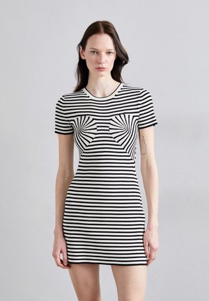 Abito a righe bianco e nere con un design aderente, maniche corte, texture a coste e un distintivo motivo a fiocco sulla parte anteriore.