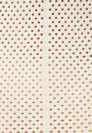 Tissu tricoté avec un motif en nid d'abeille dans des teintes blanc cassé et marron clair. Surface texturée avec des trous espacés de manière régulière et une couture centrale.