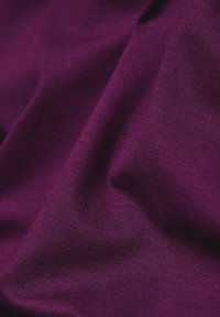 Lila Stoff mit glatter Textur, zeigt leichte Dehnbarkeit und feine Maschen, präsentiert eine gleichmäßige Farbe über die gesamte Fläche.