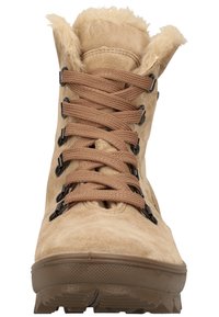 Botte d'hiver en daim beige avec lacets marron, œillets en métal noir, doublure intérieure pelucheuse et semelle robuste, vue de face.
