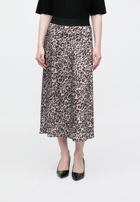 Spódnica w panterkę z czarnym elastycznym pasem. Powiewający materiał, długość do połowy łydki, miękka faktura, do kompletu czarne szpilki w szpic.