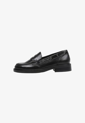 Mocasines de cuero negro con punta redonda, costura decorativa y cordones laterales. Presentan un tacón bajo y una textura suave.