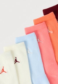 Πέντε ζεύγη πλεκτές κάλτσες σε λευκό, ανοιχτό μπλε, ροζ, πορτοκαλί και βουργουνδίσιο, κάθε μία με μικρό κεντημένο λογότυπο Jumpman.