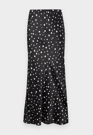 Jupe en satin noir présentant une coupe évasée et des pois blancs de tailles variées, avec une texture lisse et un tombé élégant.