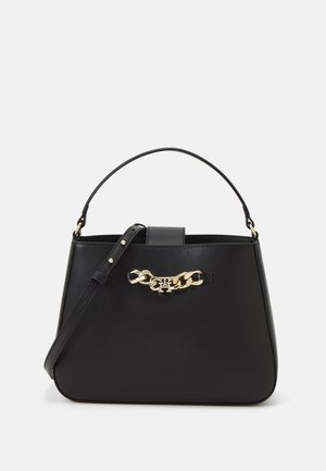 Zwarte leren handtas met korte handgreep en verstelbare schouderband, voorzien van een gouden ketting en logodetail aan de voorkant.