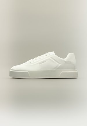 Hvid lavtop sneaker med snøredesign og diskret Calvin Klein-logo på siden, sat mod en neutral baggrund.
