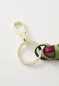 Porte-clés avec une quincaillerie en métal doré, un anneau circulaire et des accents en cuir multicolores dans des tons de vert, de brun et de rouge, mettant en valeur un design tressé.