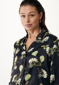 Camicia nera con bottoni, dal motivo floreale che presenta pere verdi e fiori bianchi; realizzata in un tessuto morbido e leggero, con una vestibilità rilassata.