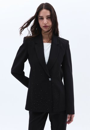 Schwarze Blazer mit tailliertem Schnitt, verziert mit dekorativen Perlendetails auf der Vorderseite, mit einem einzelnen Knopfverschluss und Reverskragen.