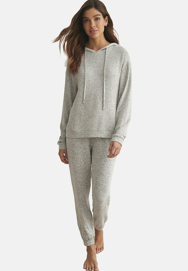 Ensemble de détente gris clair comprenant un haut à capuche avec cordons de serrage et un pantalon assorti. Texture douce avec un motif tacheté. Coupe décontractée.