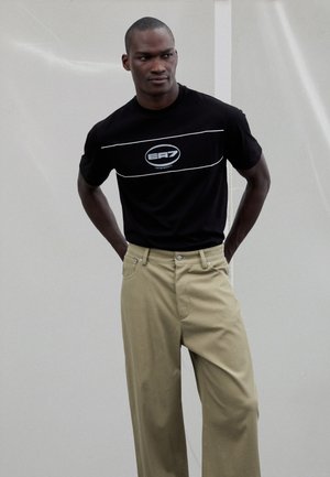 EA7 Emporio Armani TRAIN LOGO TEE UNISEX - T-shirt con stampa - black/silver coloured