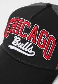 Sort baseball cap med rød "CHICAGO" og hvid "Bulls" broderi. Har tekstureret grå mesh-bagdel og buet skygge.