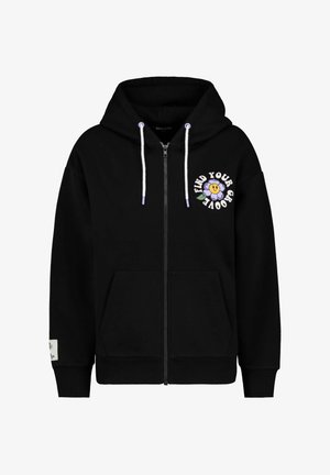 Zwarte hoodie met rits en een grafische print aan de voorkant met de tekst "VIND JE GROOVE" en een lachend bloemenontwerp. Bevat trekkoorden en voorzakken.