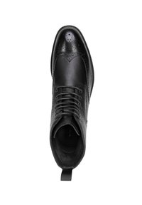 Černá kožená bota s lesklou špičkou, detaily v brogue stylu a kulatými tkaničkami. Má strukturovaný povrch a poutko na patě.