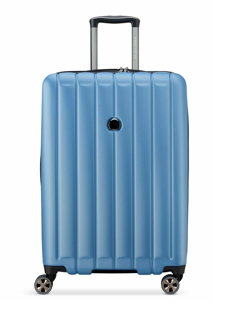 Blauwe harde koffer met verticale ribbels, uitschuifbare handgreep en vier draaibare wielen voor gemakkelijke wendbaarheid.