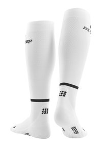 Calze compressive bianche con finitura testurizzata, con accenti neri in cima e sulla suola, progettate per un supporto e una vestibilità migliorati.