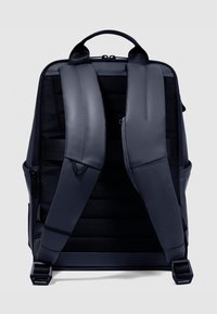 Zaino nero con spallacci imbottiti, pannello posteriore strutturato, scomparti con zip e cinghie regolabili. Dotato di maniglia superiore rinforzata.