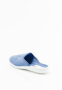 Pantofole di tessuto blu con retro aperto, texture morbida e design perforato sulla parte superiore. Presentano una suola in gomma bianca.