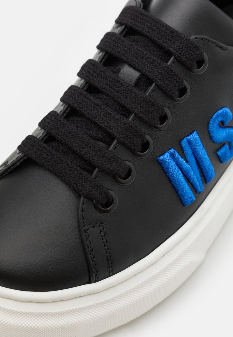 Schwarze Leder-Sneaker mit schwarzen Schnürsenkeln und blauen gestickten Buchstaben. Verfügt über eine weiße Gummisohle mit strukturierten Details.