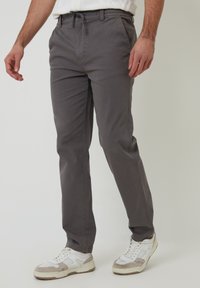 Grijze taps toelopende broek gemaakt van een katoenmix, met een drawstring taille, zijzakken en een zachte textuur.