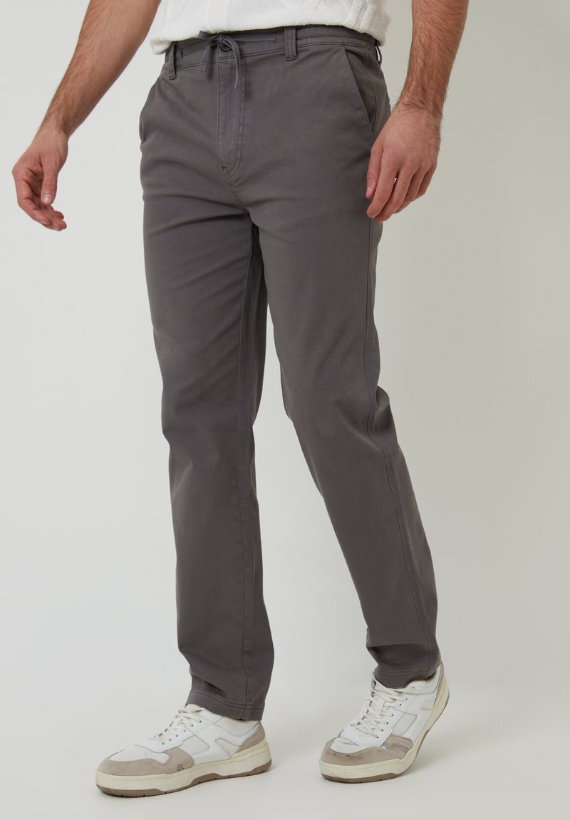 Grijze taps toelopende broek gemaakt van een katoenmix, met een drawstring taille, zijzakken en een zachte textuur.