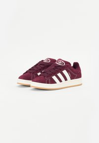 Burgunderfarbene Wildleder-Sneaker mit weißem Drei-Streifen-Design, Gummisohle, runder Zehenpartie und Logo auf der Zunge. Texturiertes Obermaterial mit Schnürung.