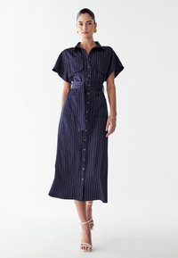 Tumesinine triibuline midi kleit lühikeste varrukatega, nööbid ees, vöö taljes ja kaks esikot. Sile kangas ja mugav lõige.