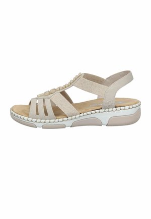 Sandale beige pour femme avec des brides élastiques, des perles décoratives sur le dessus, une semelle intérieure rembourrée et une semelle extérieure blanche en caoutchouc avec motifs antidérapants.