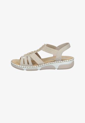 Sandale beige pour femme avec des brides élastiques, des perles décoratives sur le dessus, une semelle intérieure rembourrée et une semelle extérieure blanche en caoutchouc avec motifs antidérapants.