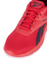 Czerwone sneakersy Reebok mają siateczkową cholewkę, skórzane akcenty i czarne detale. Zawierają sznurówki oraz teksturowaną gumową podeszwę.