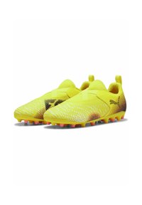 Le scarpe da calcio gialle presentano una parte superiore liscia con accenti testurizzati e un motivo di linee. La suola ha tacchetti rosa per una migliore trazione.