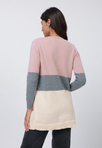 Knit sweater featuring a color-block design with pink, gray, and cream sections. Long sleeves and a ribbed hem add texture.