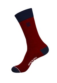 Chaussette rouge avec un revers et un orteil bleu marine, arborant un logo dans la partie supérieure et un texte blanc au niveau de la cheville. Texture lisse avec des détails subtils.