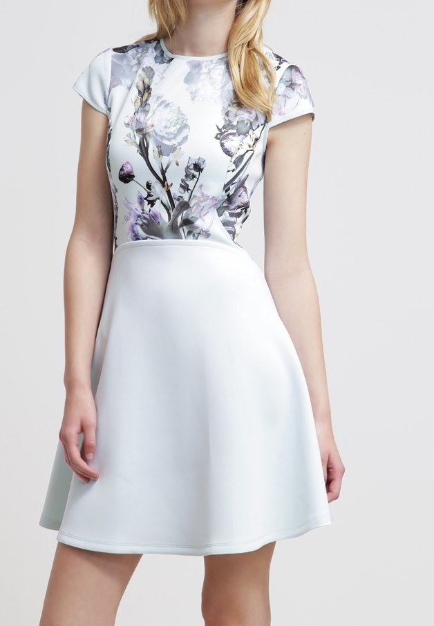 Robe fleurie avec un corsage ajusté imprimé de fleurs pastel et une jupe évasée unie bleu clair. Tissu lisse avec des manches courtes.