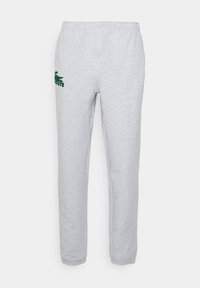 Grå joggebukser laget av blandingsbomull, med elastisk midjebånd og en grønn brodert logo på venstre lår.