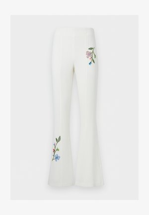 White flared pants with high waist featuring embroidered floral designs near the right hip and lower left leg.