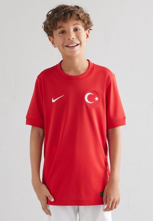 Maglia sportiva rossa realizzata in tessuto traspirante, con maniche corte, colletto a girocollo e un'emblema circolare della bandiera turca sul petto.