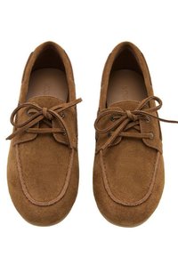 Scarpe in suede marroni con punta arrotondata, design con lacci e dettagli di cucitura a contrasto. La texture è morbida e liscia.