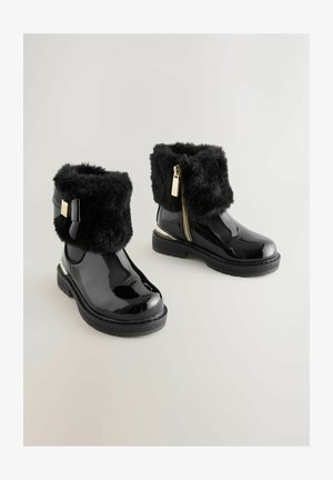 Mustad must läikivad naha ankle boots valefutuuriga, kuldse tooniga metalldetailide ja külgzipperiga. Paks kand ja dekoratiivne lipsu detail.