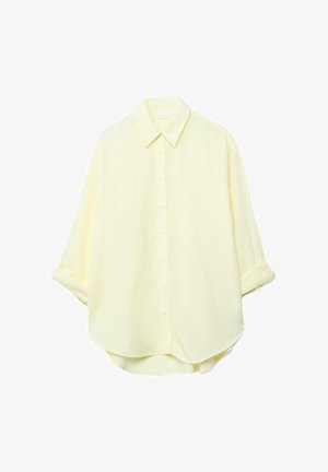 Svetlo rumena srajca z dolgimi rokavi, z gumbi na sprednji strani, zavihanimi manšetami in zaobljenim spodnjim robom, prikazana na belem ozadju.