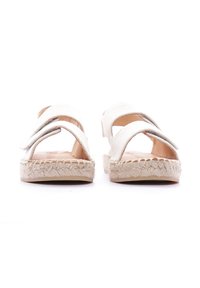 Sandalias de esparto beige con dos correas anchas, suela trenzada de yute y un acabado suave, diseñadas para comodidad y transpirabilidad.