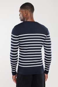 Marineblå sweater med hvide vandrette striber, ribbet tekstur og tætsiddende design. Accentueret med et lille logo på skulderen.